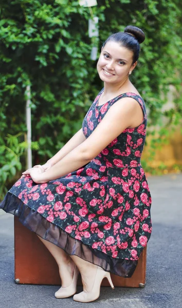 Mujer joven en falda vintage con una maleta vieja — Foto de Stock