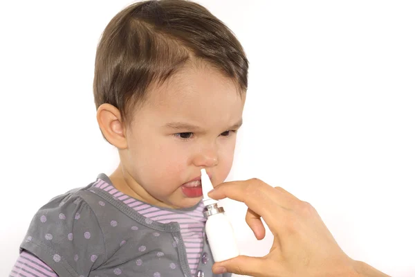 Parent's hand of a girl applies a nasal spray — Stock Photo, Image