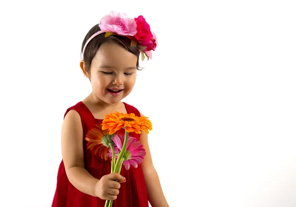 Liten flicka i röd klänning med en gerbera bukett i handen — Stockfoto