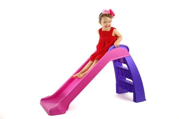 Little girl having fun on slide isolated on white — Stock Photo, Image