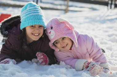 İki komik sevimli küçük karda oynayan kız kardeş