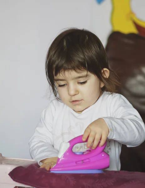 Schattig kindje Strijkservice de kleren met ijzeren speelgoed — Stockfoto