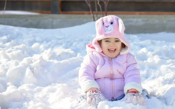 En liten flicka som leker i snö — Stockfoto