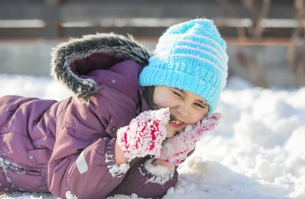 Rolig liten flicka som har roligt i vacker vinterpark under snöfall — Stockfoto