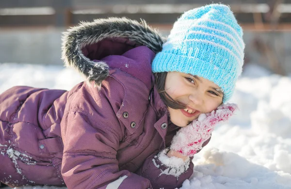 Rolig liten flicka som har roligt i vacker vinterpark under snöfall — Stockfoto