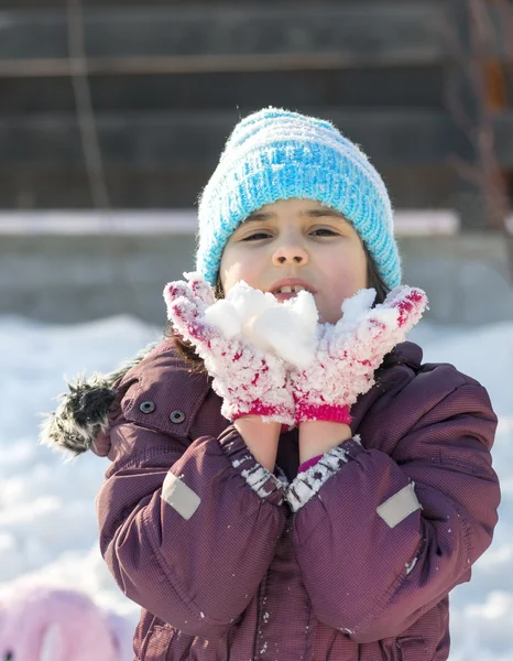 Liten flicka spelar med snö — Stockfoto