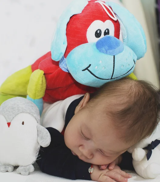 Bebê recém-nascido menino dormindo com seus brinquedos — Fotografia de Stock