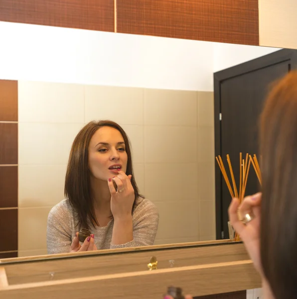 Mujer joven arreglándose en el baño por la mañana — Foto de Stock