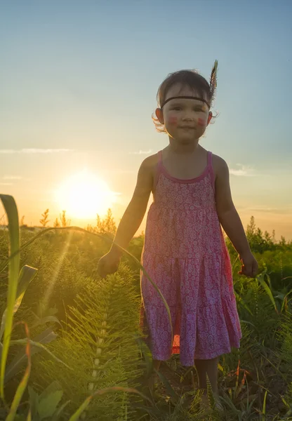 Lustiges kleines Mädchen als Indianerin mit Maracas und Feder — Stockfoto