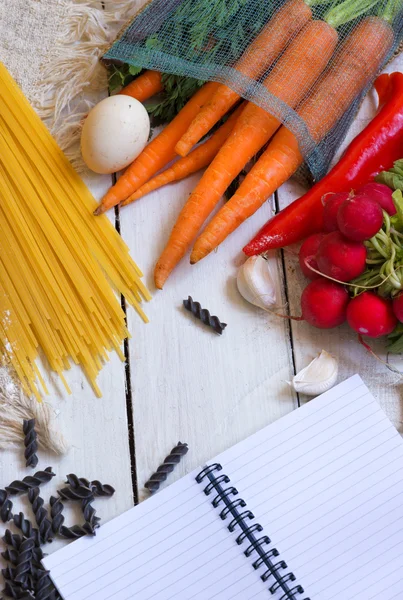 Makarna için malzemeler: spagetti, sebze ve baharat ve eski masanın üzerine bir not defteri. Üstten Görünüm — Stok fotoğraf