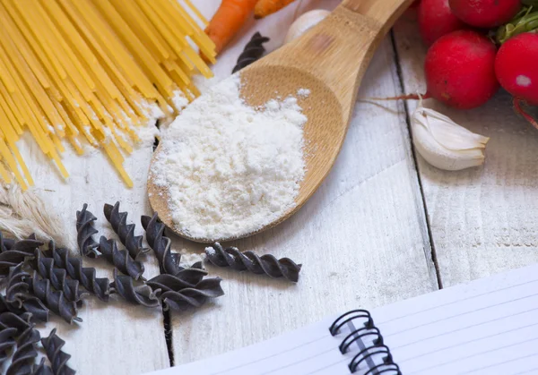 Makarna için malzemeler: spagetti, sebze ve baharat ve eski masanın üzerine bir not defteri. Üstten Görünüm — Stok fotoğraf