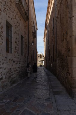 Extremadura, İspanya 'daki antik Caceres şehrinin sokaklarında yürüyen ve eğlenen insanlar. Bu ortaçağ kenti UNESCO Dünya Mirası Alanı olarak ilan edilmiştir..