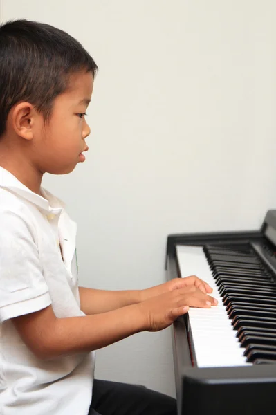 Japanese boy playing a piano (5 years old) — Stock Photo, Image