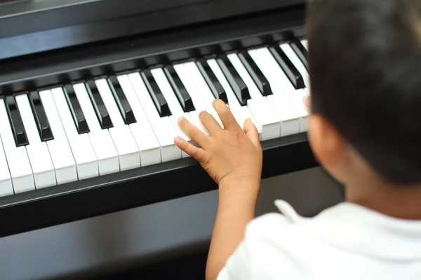 Japanese boy playing a piano (5 years old) — Stock Photo, Image