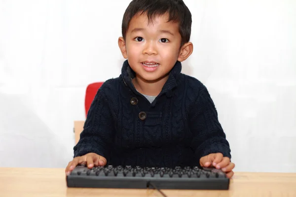 Ragazzo giapponese mettendo una tastiera (4 anni ) — Foto Stock