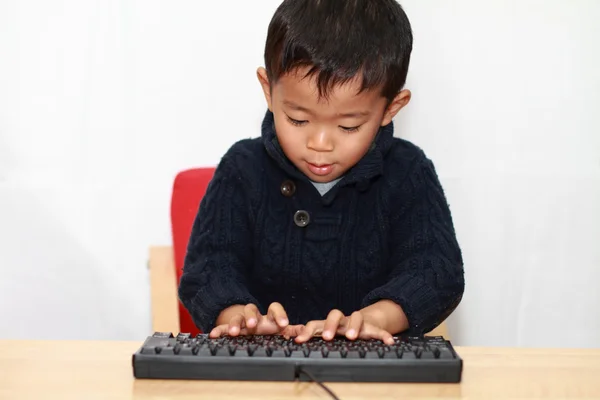 Ragazzo giapponese mettendo una tastiera (4 anni ) — Foto Stock