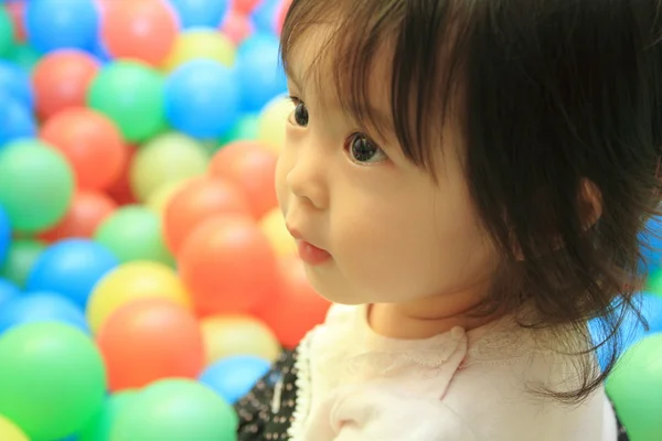 Japansk flicka spelar i bollhav (1 år gammal) — Stockfoto