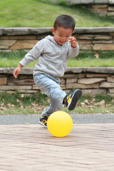 Japonês menino chutando uma bola amarela (3 anos de idade ) — Fotografia de Stock