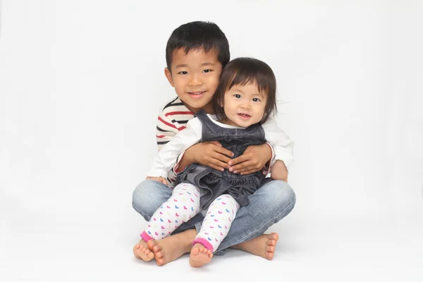 Japonés hermano y hermana sentado en su rodilla (6 años chico y 1 año chica ) —  Fotos de Stock