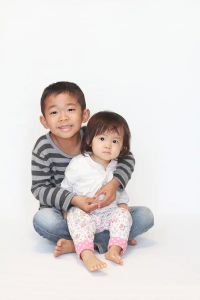 日本の兄と妹 (6 歳の男の子と 1 歳の女の子、彼の膝の上に座って) — ストック写真