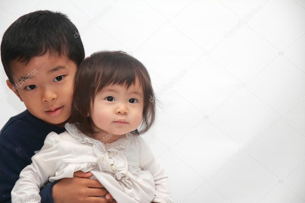 Japanese brother and sister sitting on his knee (6 years old boy and 1 year old girl)