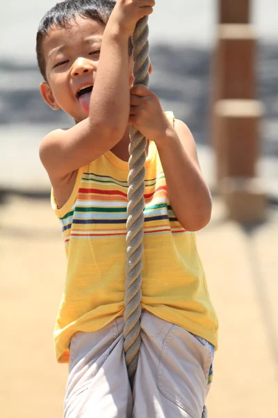 Японський хлопчик грає з мотузкою Тарзан (4 роки).) — стокове фото