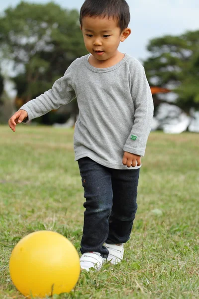 Japonés chico pateando un amarillo pelota (3 años de edad ) —  Fotos de Stock