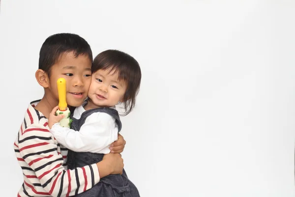 日本の兄と妹は、お互い (6 歳の男の子と 1 歳の女の子を抱いて) — ストック写真