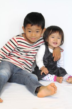 Japon kardeşi ve kız kardeşi (6 yaşında çocuk ve 1 yaşındaki kız birbirlerine sarılma)