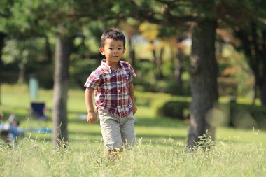 Japon çocuk (4 yaşında çimenlerin üzerinde çalışan)