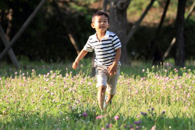 Japon çocuk (4 yaşında çimenlerin üzerinde çalışan)
