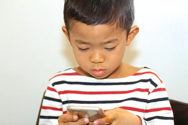 使用智能手机 （6 岁的日本男孩) — 图库照片