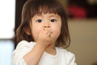 Japon küçük tahıl (1 yaşında yeme kız)