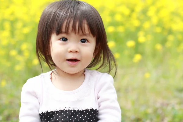 Menina japonesa (1 ano de idade) e mostarda campo amarelo — Fotografia de Stock