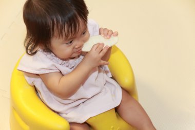 Japon küçük pirinç kraker (0 yaşındaki yiyen kız)