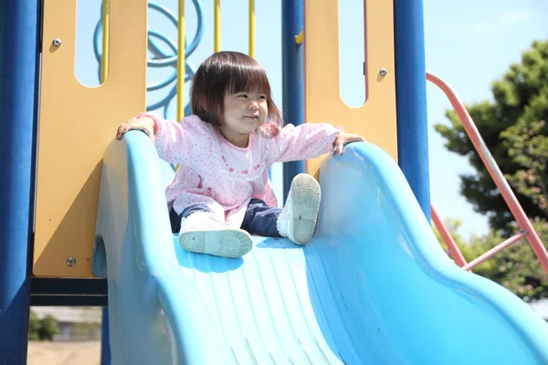 Japanisches Mädchen auf der Rutsche (1 Jahr alt)) — Stockfoto