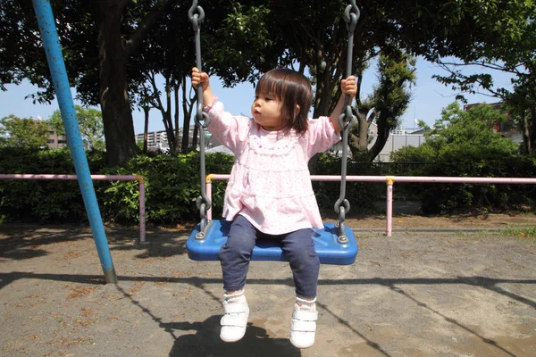 Японская девушка на качелях (1 год ) — стоковое фото