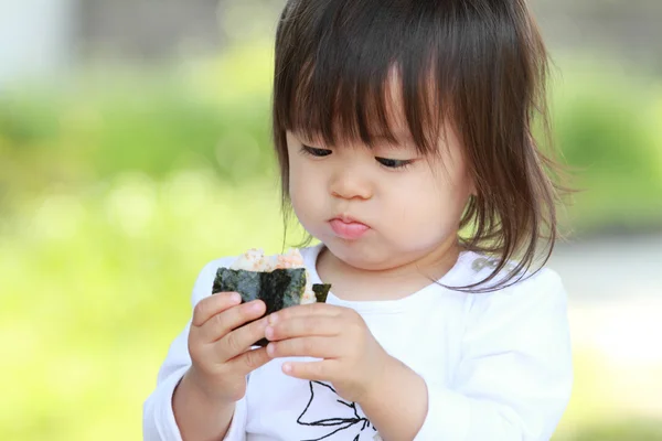 Japansk flicka äter ris boll (1 år gammal) — Stockfoto