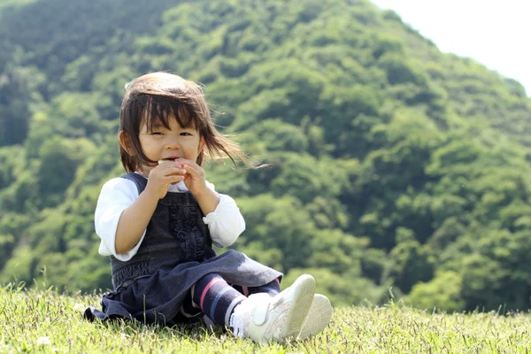 Japon kız yemek pirinç kraker (1 yaşında) — Stok fotoğraf