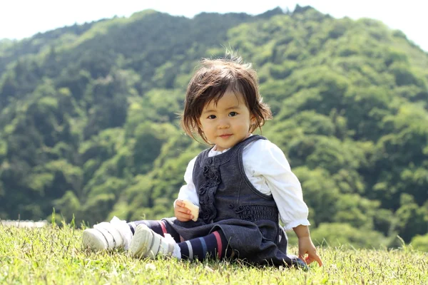 Японская девушка ест рисовое печенье (1 год ) — стоковое фото