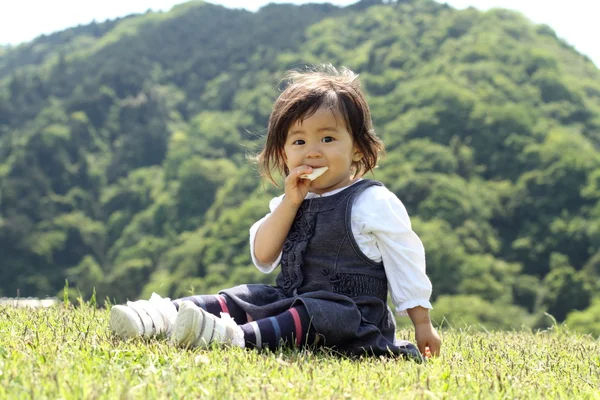 Japonská dívka jíst rýži krakování (1 rok starý) — Stock fotografie