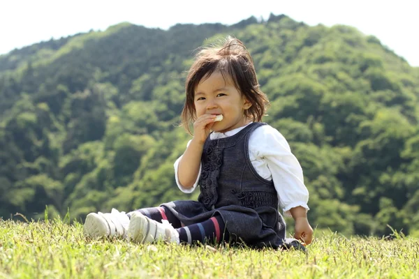 Japon kız yemek pirinç kraker (1 yaşında) — Stok fotoğraf