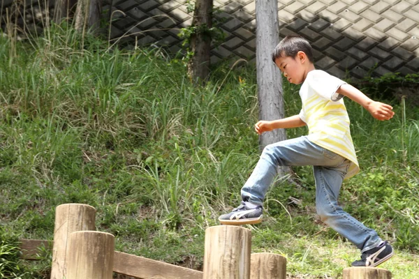 Japonês menino jogando no campo atlético (primeira série na escola primária ) — Fotografia de Stock