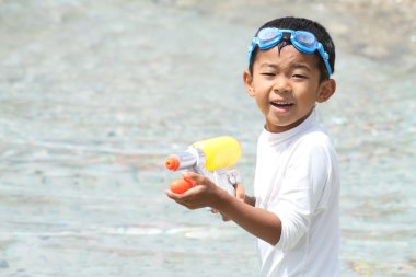 Japon çocuk su tabancası ile oynarken (birinci sınıftan ilköğretim okulunda)