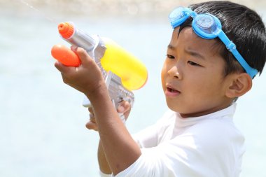 Japon çocuk su tabancası ile oynarken (birinci sınıftan ilköğretim okulunda)