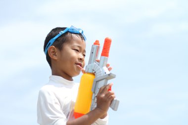 Japon çocuk su tabancası ile oynarken (birinci sınıftan ilköğretim okulunda)