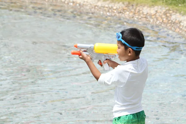 Japonês menino brincando com arma de água (primeira série na escola primária ) — Fotografia de Stock