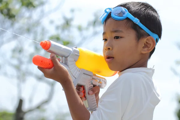 Japansk dreng leger med vandpistol (første klasse på grundskolen ) - Stock-foto