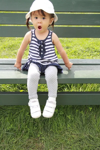 Japanese girl sitting on the bench in the field (1 year old) — Stock Photo, Image