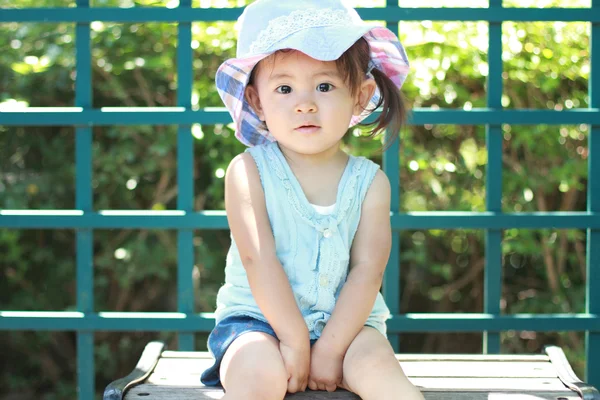 Japanisches Mädchen sitzt auf der Bank (1 Jahr alt)) — Stockfoto